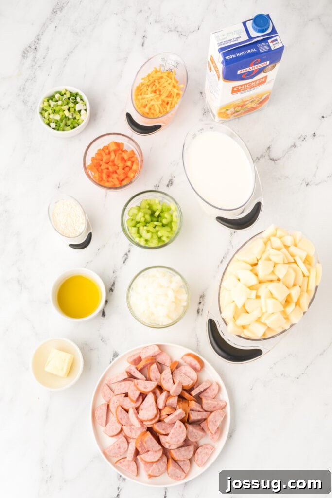 Overhead view of prepped ingredients for cheesy kielbasa potato soup including chopped veggies, diced potatoes, sliced sausage, broth, cheese, milk, butter, and flour on a marble surface.