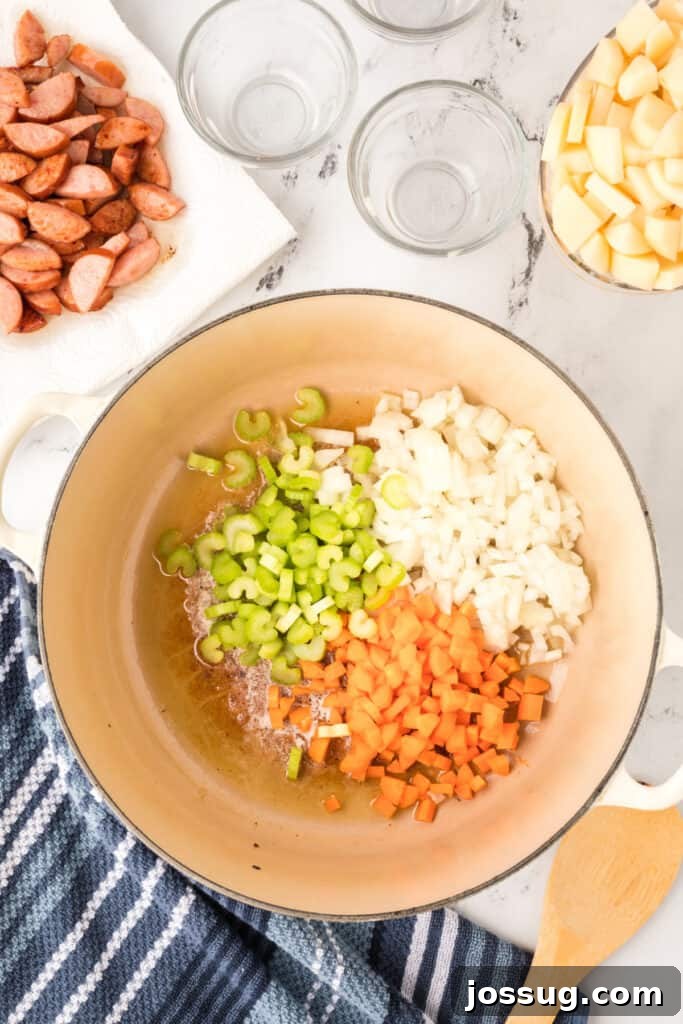 Chopped celery, onion, and carrots added to the pot with melted butter.