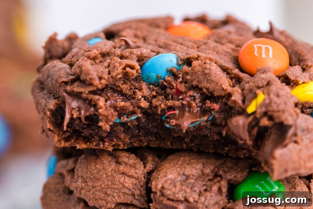 Cross-section of an M&M cookie, revealing its soft, chocolatey interior and melted M&M candies, highlighting its perfect texture.