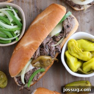Tender Slow Cooker Italian Beef Sandwiches 2 A perfectly assembled Slow Cooker Italian Beef Sandwich with melted provolone cheese and pepperoncini.