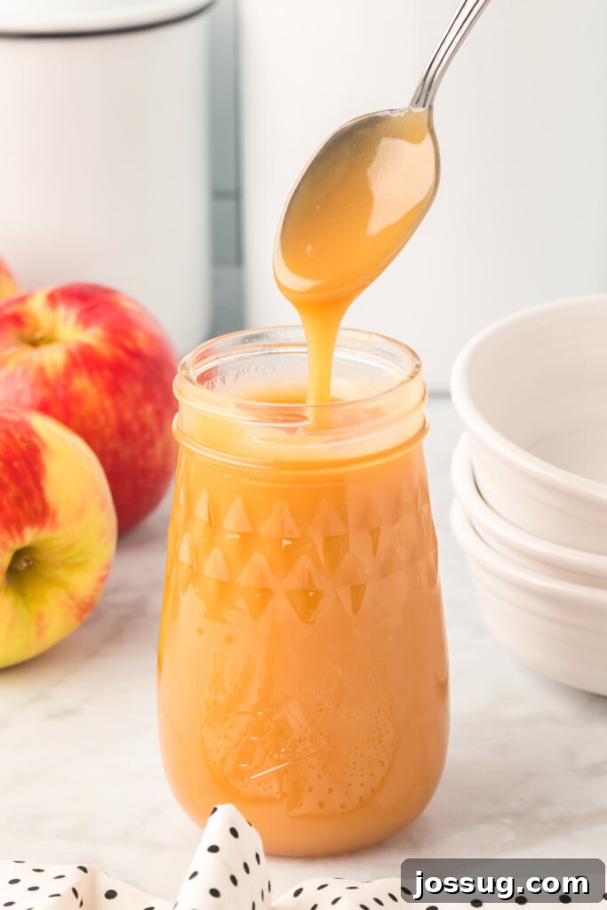Decadent Caramel 2 Homemade caramel sauce in a jar with a spoon, showing its rich, golden texture.