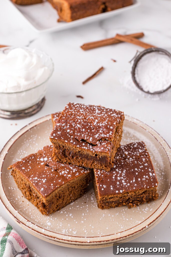 Stacked pieces of rich, moist gingerbread cake, showcasing its perfect texture and ready to be enjoyed.