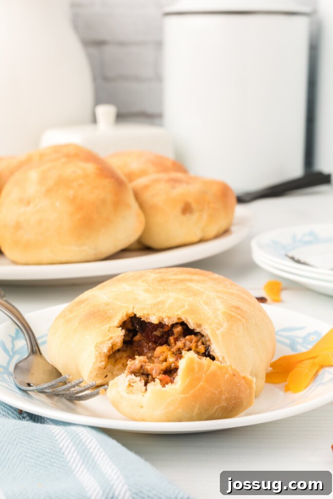 Loaded BBQ Bacon Cheeseburger Buns 3 A BBQ Bacon Cheeseburger Bun cut in half, revealing the generous and flavorful filling of ground beef, bacon, and melted cheese.