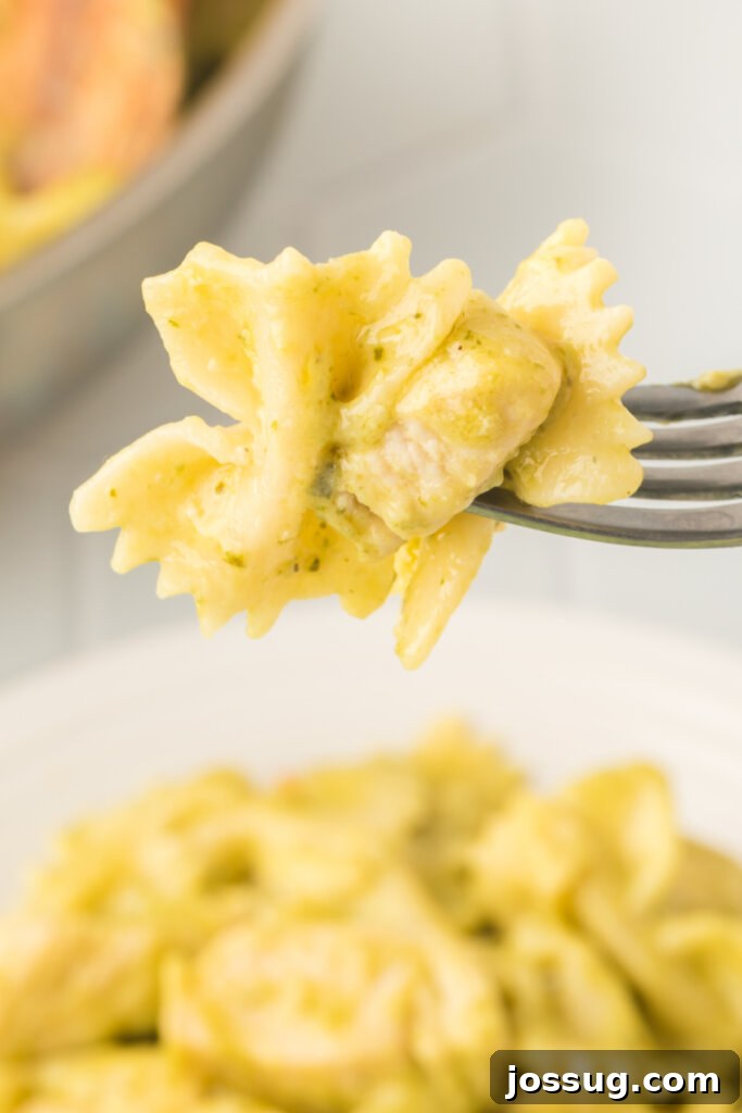 bite of creamy chicken pesto pasta on a fork