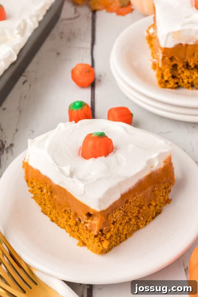 Decadent Pumpkin Spice Poke Cake 2 Plated slice of pumpkin pudding cake with candy pumpkins and fall setup