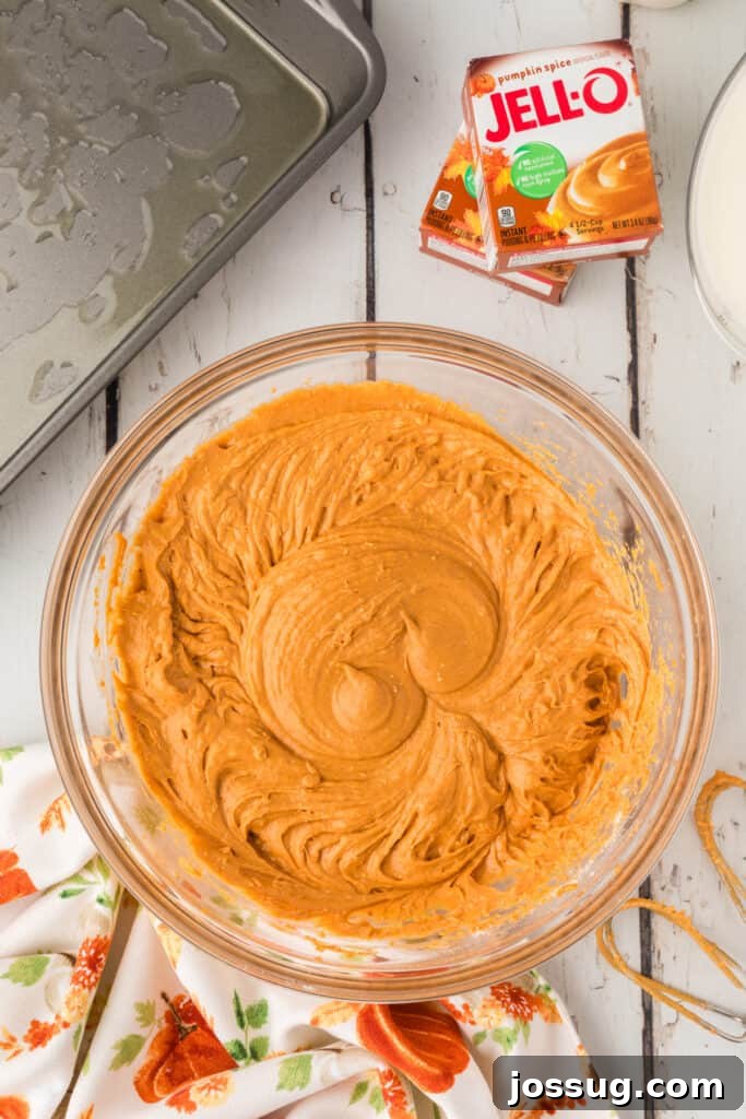 Decadent Pumpkin Spice Poke Cake 5 Pumpkin cake batter fully mixed in a clear glass bowl
