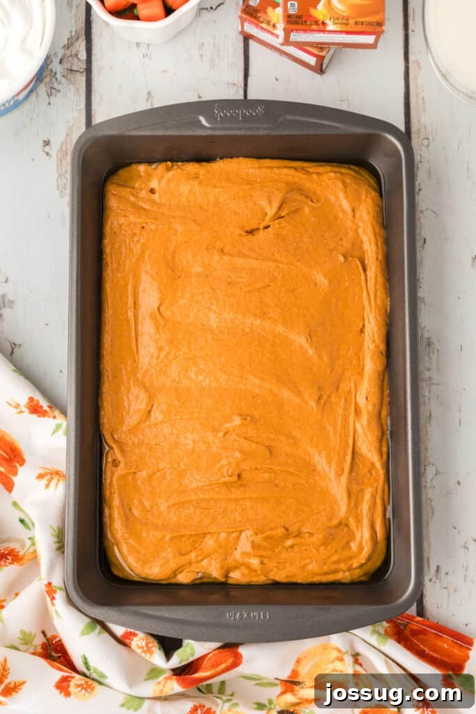 Decadent Pumpkin Spice Poke Cake 6 Unbaked pumpkin cake batter spread in a greased 9x13 baking pan