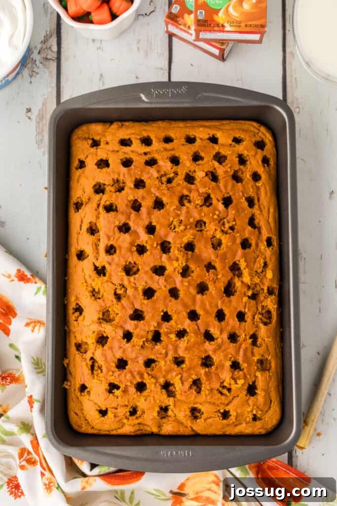 Decadent Pumpkin Spice Poke Cake 8 Baked cake with evenly spaced holes poked across the top