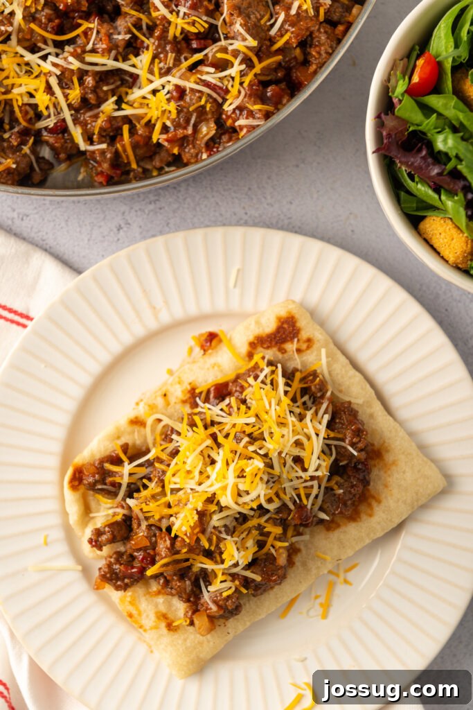 Overhead view of a prepared BBQ Bacon Cheeseburger Flatbread Melt on a plate with fresh broccoli.