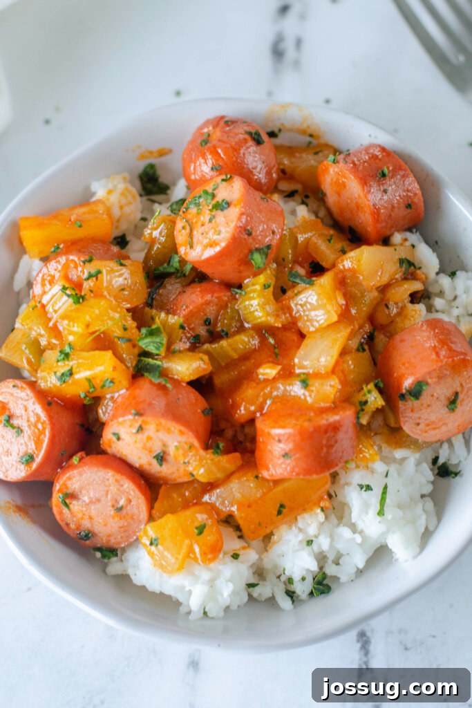 bowl with sweet and sour hot dogs over rice