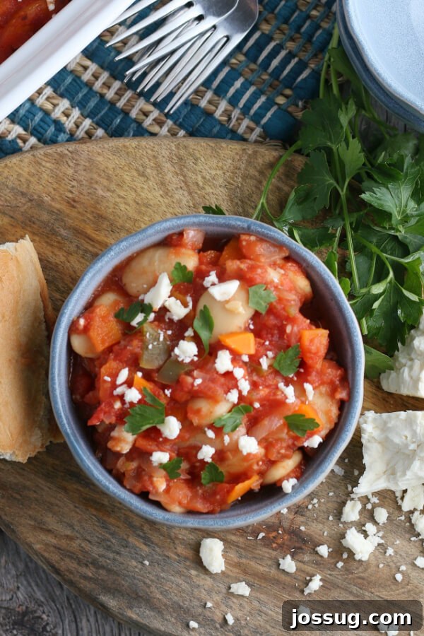 A bowl of finished Greek Baked Beans recipe, garnished and ready to serve