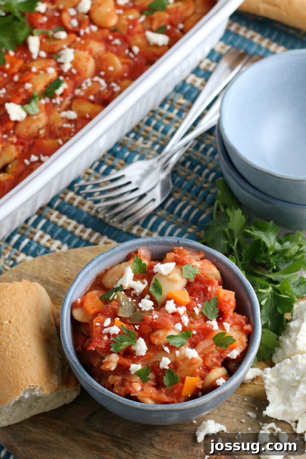 Close-up of a serving of Greek Baked Beans ready to be eaten, showcasing its rich texture and sauce