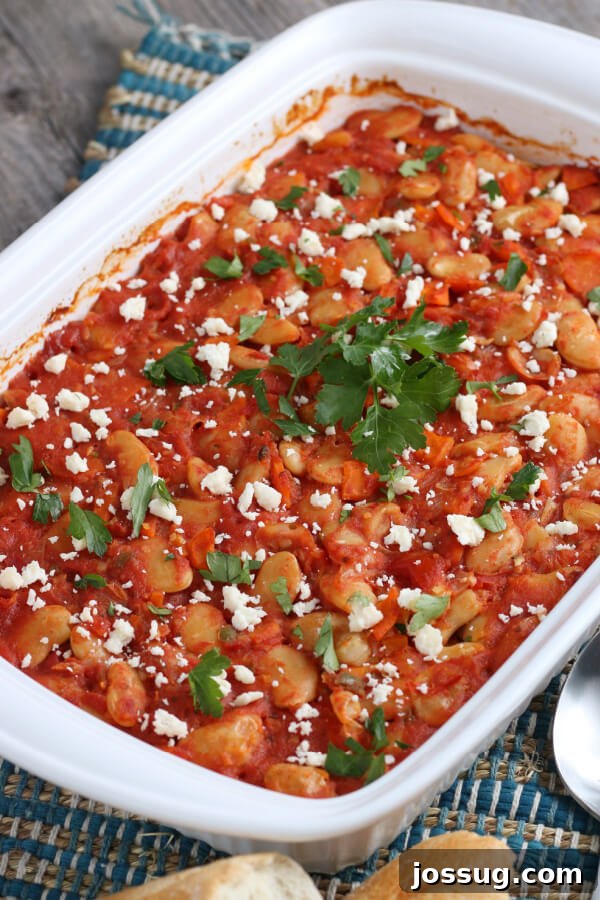 The finished Greek Baked Beans casserole, hot out of the oven, with a rich, bubbling sauce