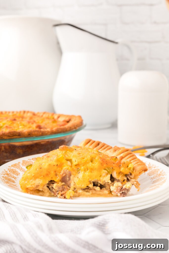 Savory Roast Beef and Gruyère Quiche 4 side view of a generous slice of roast beef quiche, showcasing its layers