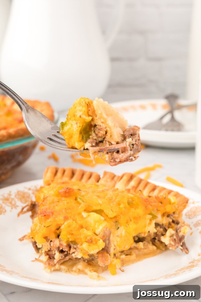 Savory Roast Beef and Gruyère Quiche 5 a bite of roast beef quiche on a fork, showing the rich filling