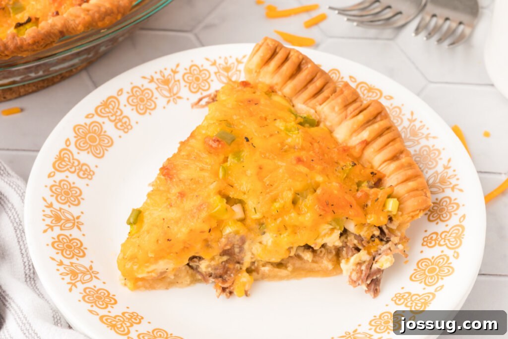 Savory Roast Beef and Gruyère Quiche 6 roast beef quiche slice on a white plate, ready to be served