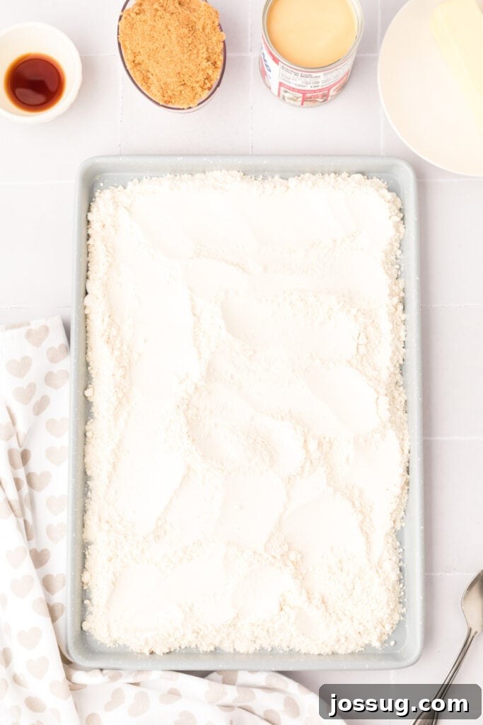 Baking sheet spread with all-purpose flour, ready to be baked to heat-treat it and make it safe for edible cookie dough consumption.