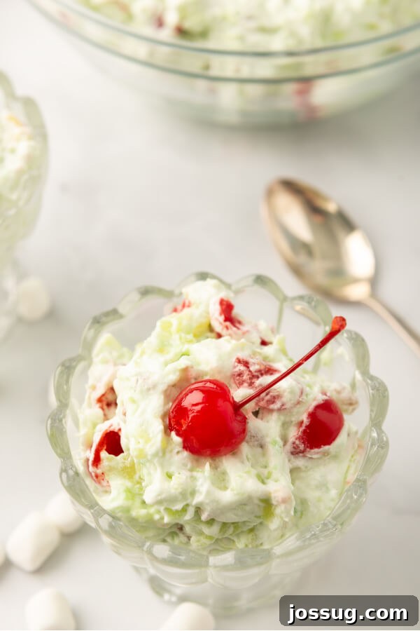 Green Jewel Salad 2 Pistachio salad with maraschino cherries in a serving bowl, ready to be enjoyed.