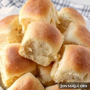 A freshly baked batch of soft and golden buttery rolls arranged in a baking dish, ready to be served.