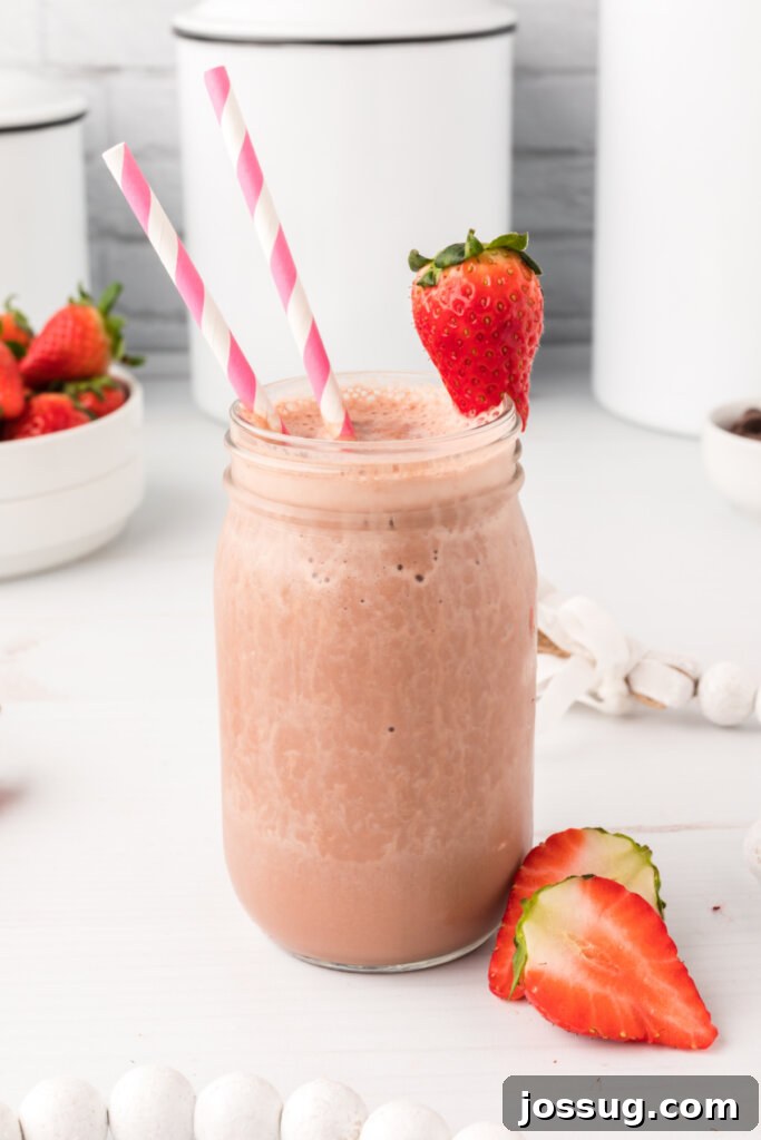 A close-up of a chocolate covered strawberry protein smoothie, highlighting its smooth texture and rich color.