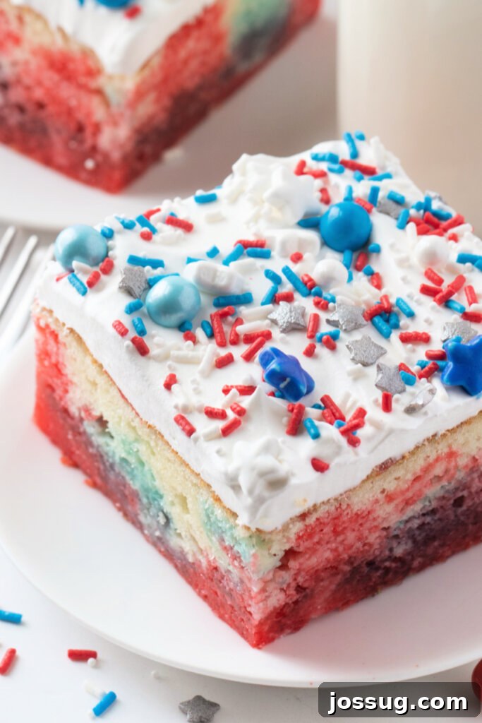An inviting overhead shot of a slice of Patriotic Jello Poke Cake, highlighting the vibrant colors and creamy topping