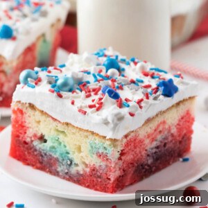 Closeup of a patriotic jello poke cake slice on a plate, garnished with a few red, white, and blue stars