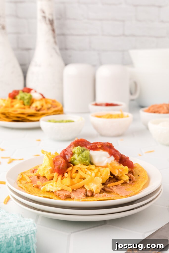 Crispy Morning Fiesta 2 Two beautifully arranged breakfast tostadas on a plate, garnished with fresh cilantro and lime, ready to be enjoyed.