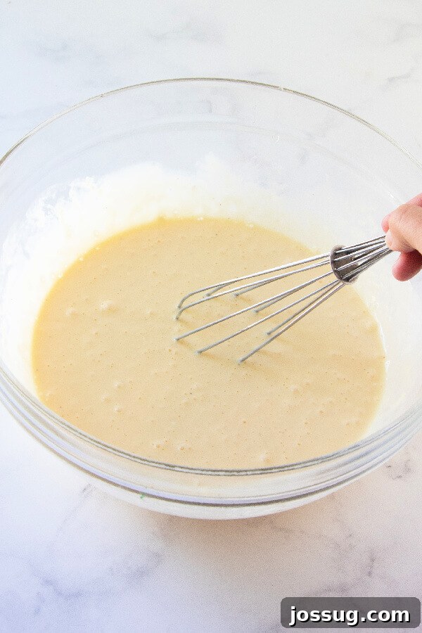 A close-up view of the egg mixture in a bowl, showcasing its smooth, creamy texture before other ingredients are added.