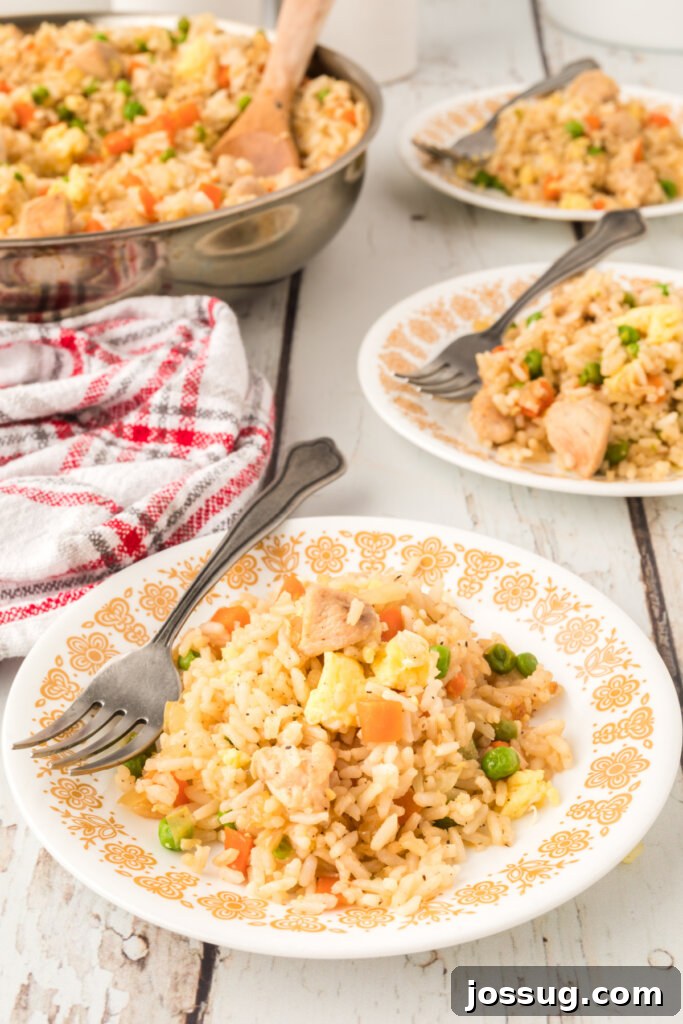 Close-up of a plate of vibrant chicken fried rice with a fork