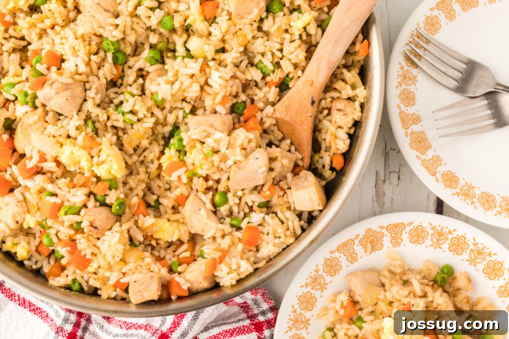 Overhead view of a skillet and a plate with golden chicken fried rice