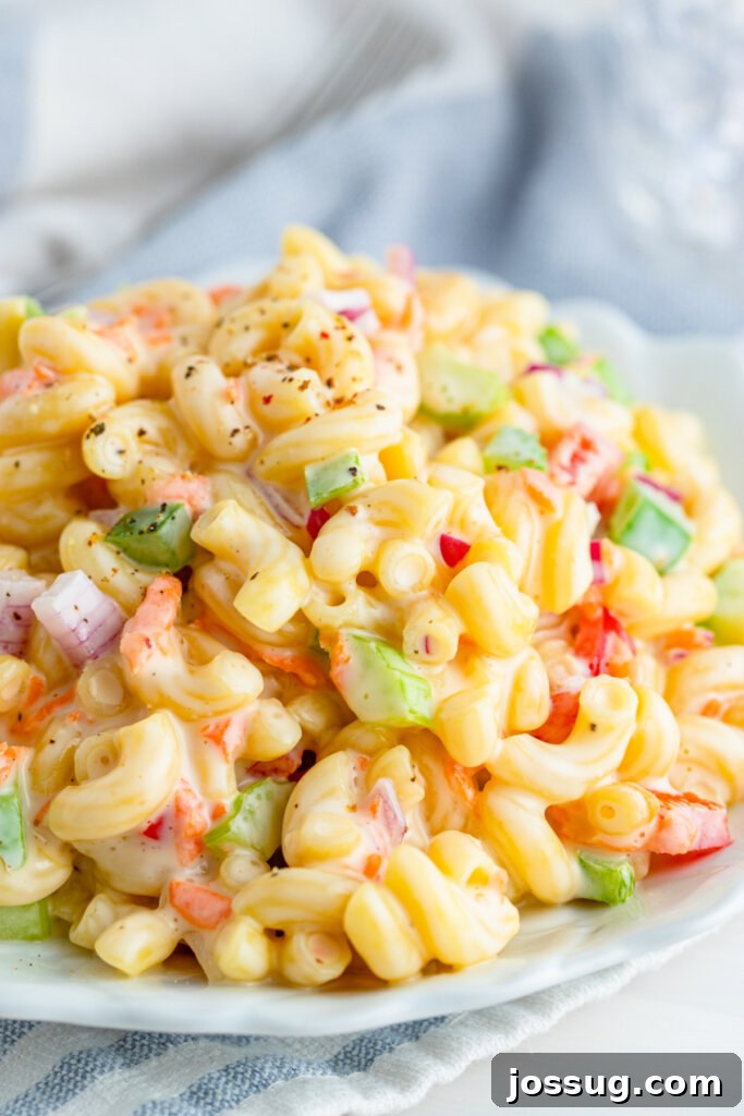A large bowl of classic macaroni salad, perfectly chilled and ready to serve at a summer gathering.