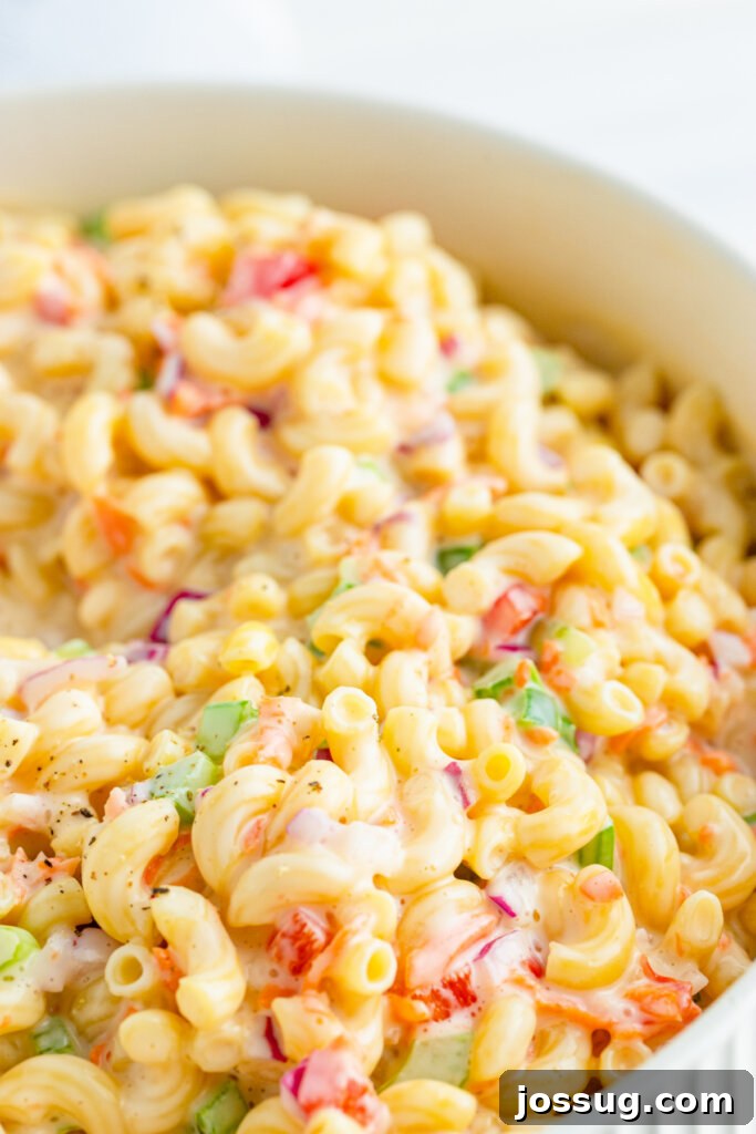 An overhead view of a creamy macaroni salad, showcasing its vibrant colors and rich texture in a serving bowl.