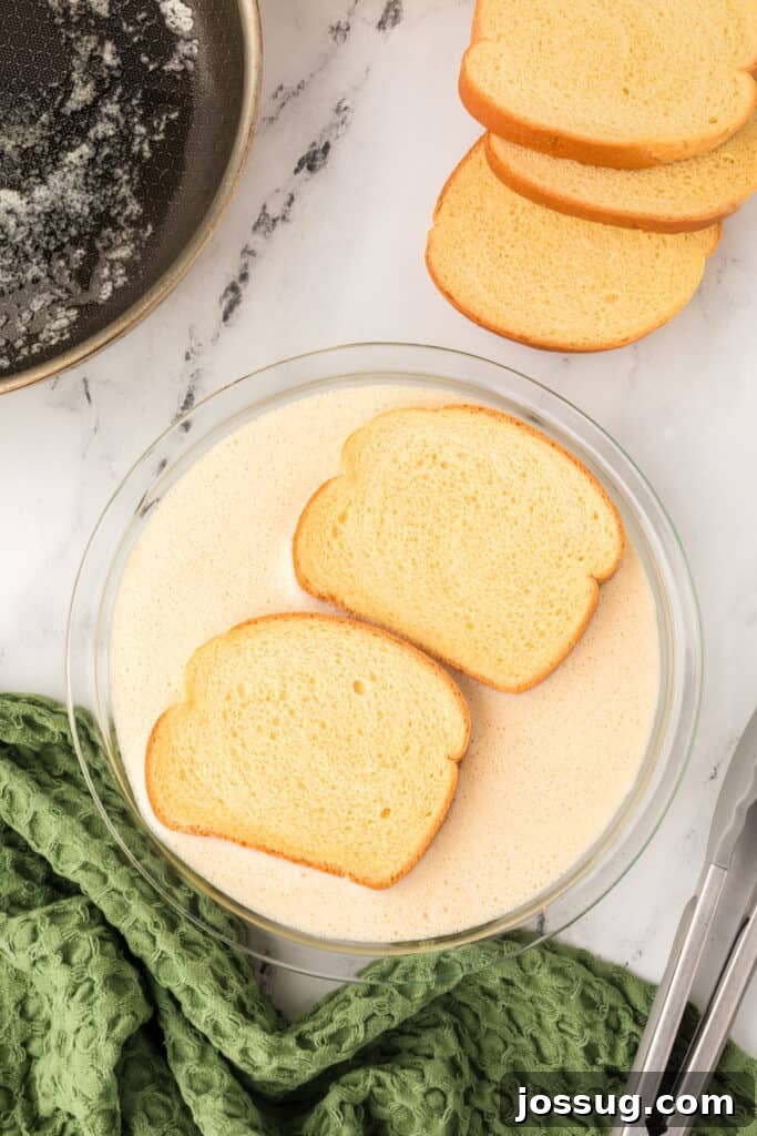 Eggnog Infused Brioche 7 Slices of bread soaking in creamy eggnog mixture in a glass pie plate beside skillet.