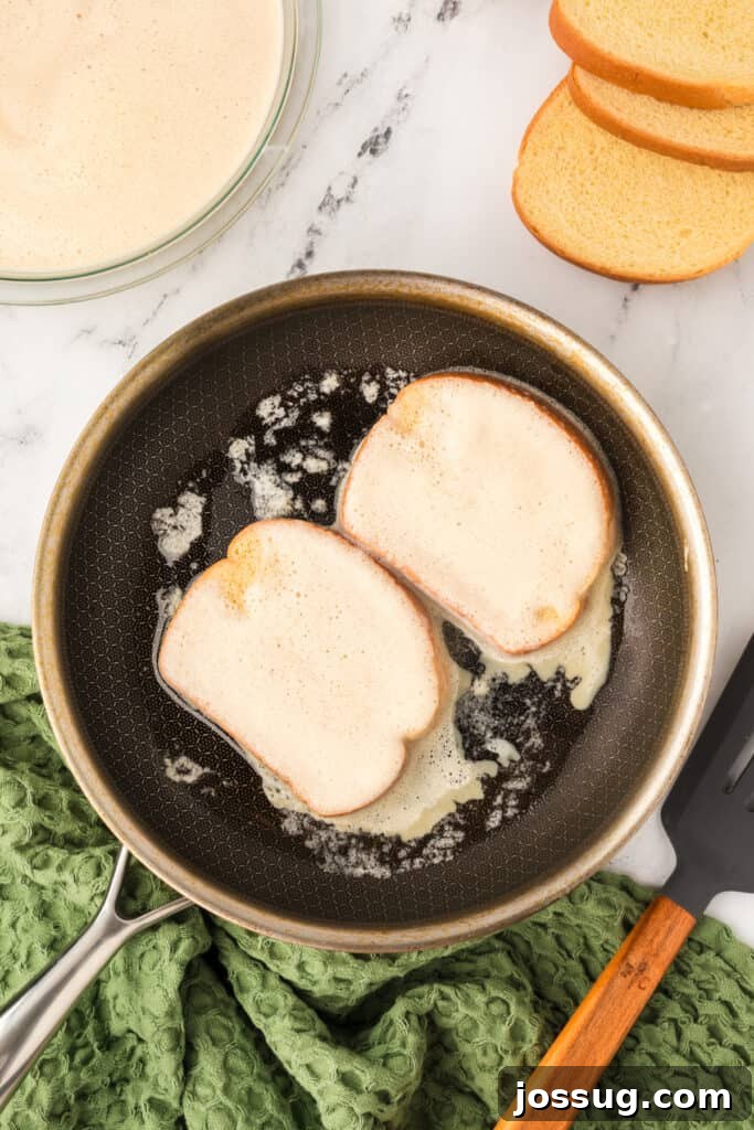 Eggnog Infused Brioche 9 Bread slices cooking in buttered skillet until golden for Eggnog French Toast.