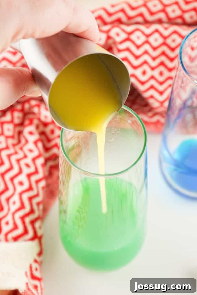 Orange juice being poured into the Blue Curacao