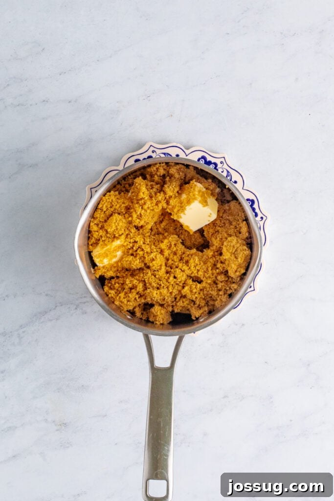 Toffee Graham Bliss Bites 3 Saucepan filled with packed dark brown sugar and chunks of butter on a marble surface