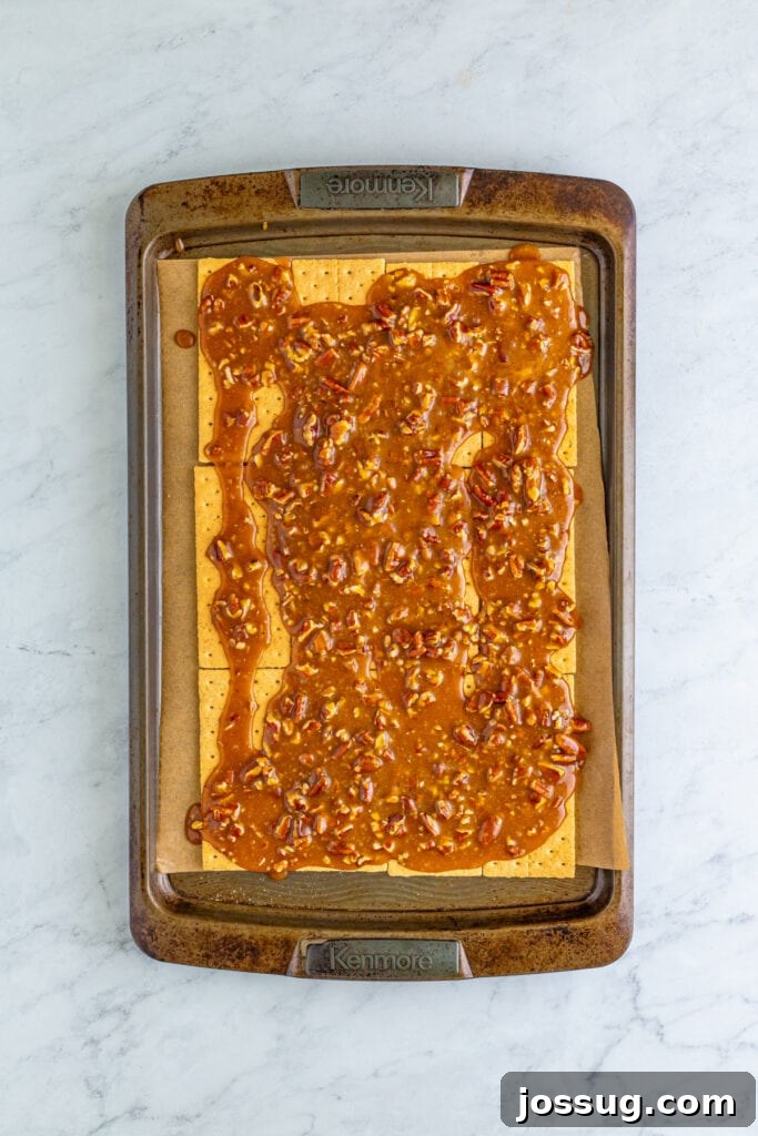 Toffee Graham Bliss Bites 6 Graham crackers on a parchment-lined baking sheet topped with warm caramel pecan mixture