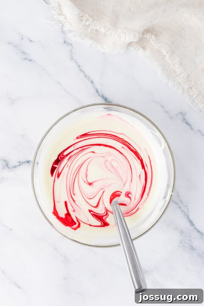 Bowl of melted white candy coating swirled with pink food coloring, ready for dipping Valentine truffles.