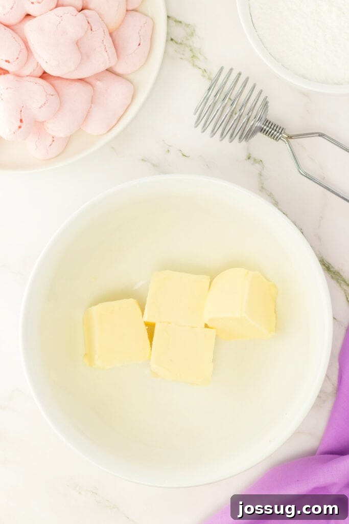 Bowl of softened butter cut into cubes for making vanilla buttercream filling.