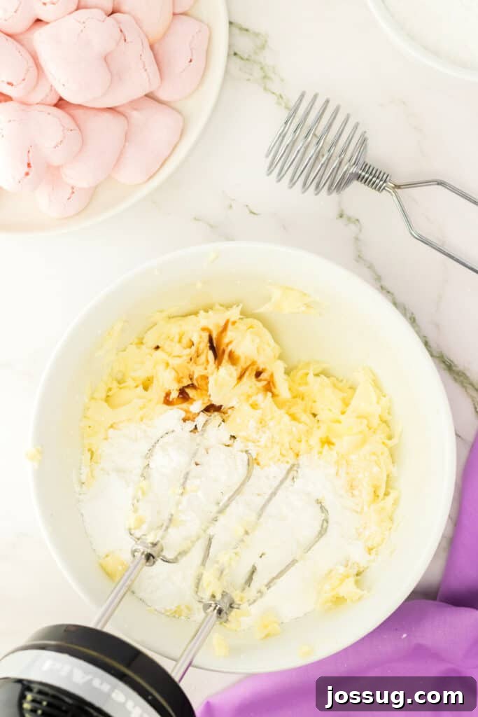 Powdered sugar and butter being mixed together with an electric hand mixer.