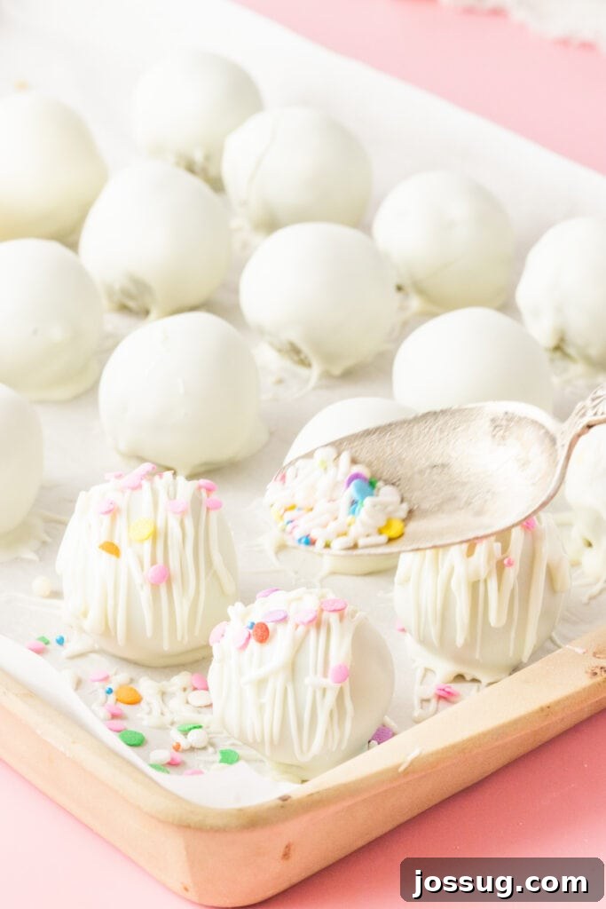 Decorating white chocolate cake truffles with colorful sprinkles