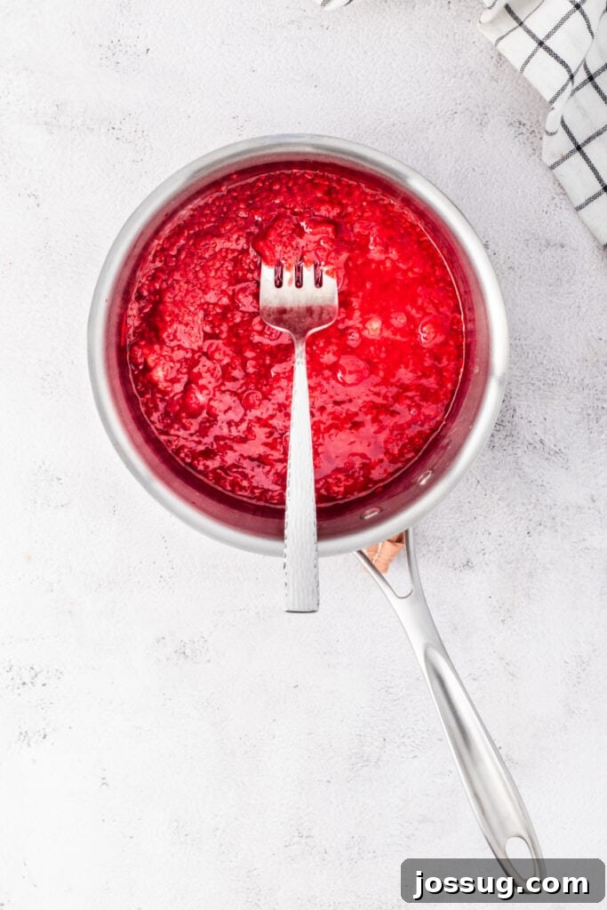 Raspberry mixture thickening in a saucepan