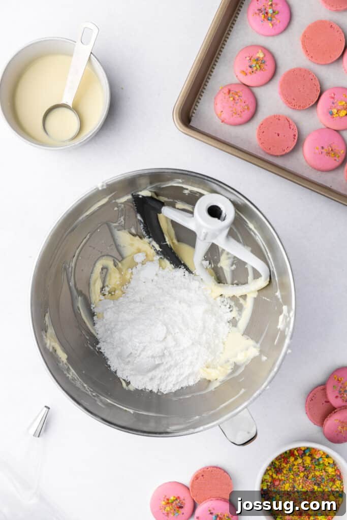 powdered sugar added to buttercream in a stand mixer bowl