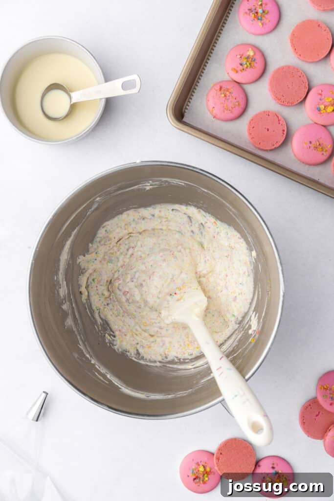 fruity pebbles buttercream fully mixed in a stand mixer bowl