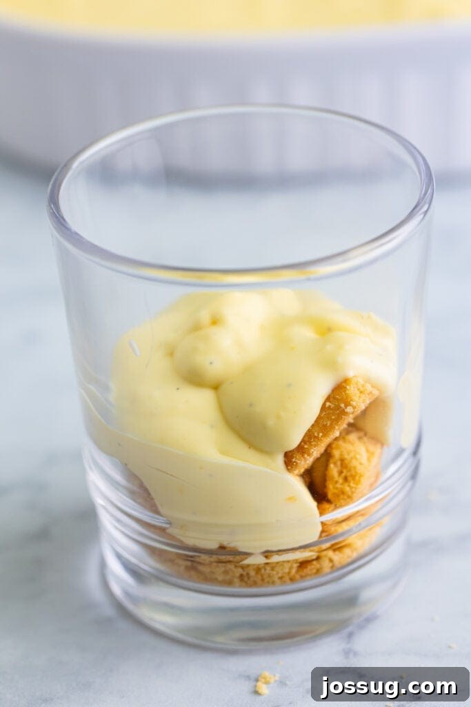 Creme Brulee Dream Trifle 13 Vanilla custard spooned over shortbread cookies in a clear trifle glass, creating a creamy layer.