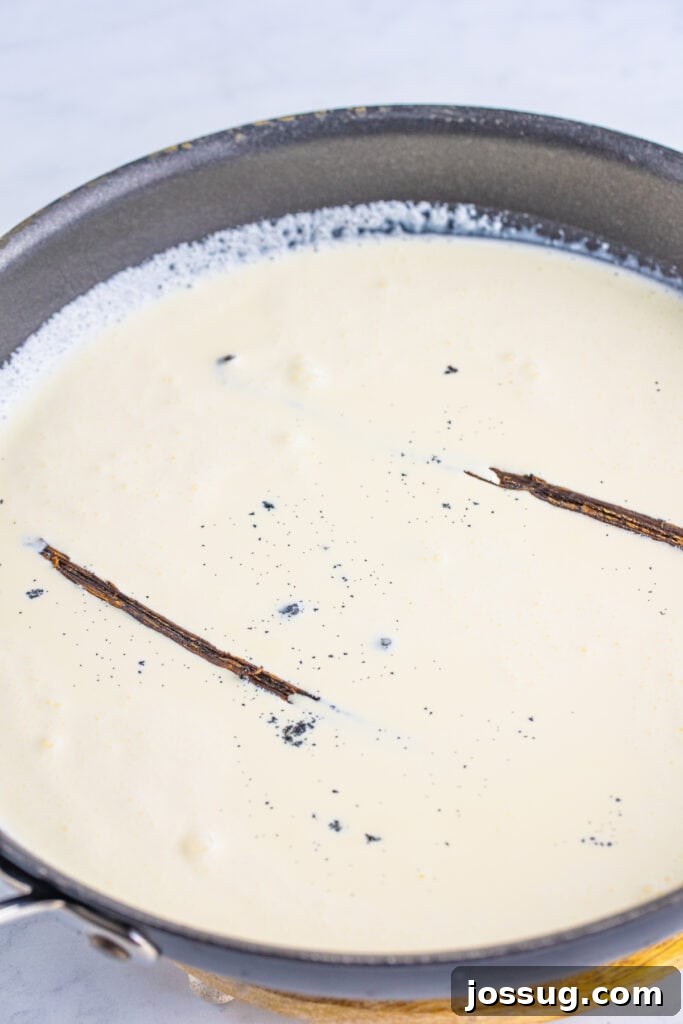 Creme Brulee Dream Trifle 5 Vanilla bean pods steeping in warm cream, infusing the liquid with a rich vanilla aroma.