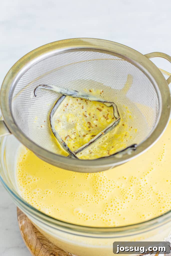 Creme Brulee Dream Trifle 7 Creme brulee custard being strained through a fine-mesh strainer, ensuring a silky smooth texture.