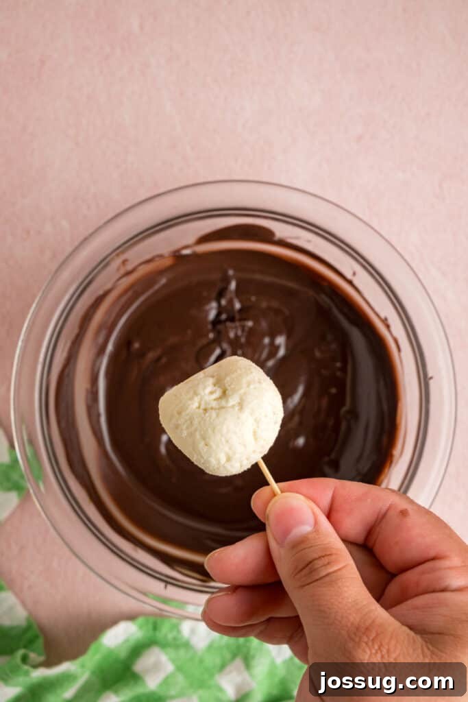 Buttercream Bliss Bites 15 Buttercream ball held on a toothpick above melted chocolate