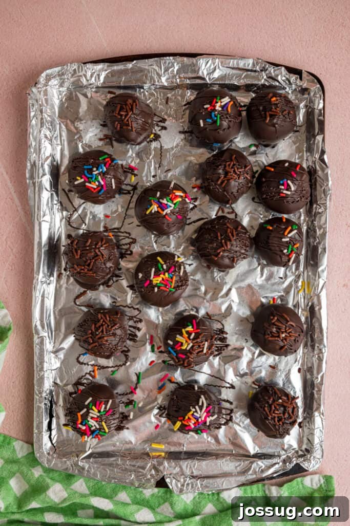 Buttercream Bliss Bites 17 Chocolate coated buttercream truffles with sprinkles on a foil lined baking sheet