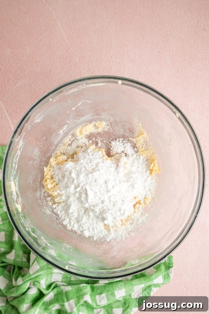 Buttercream Bliss Bites 5 Powdered sugar added to the butter mixture in a glass mixing bowl